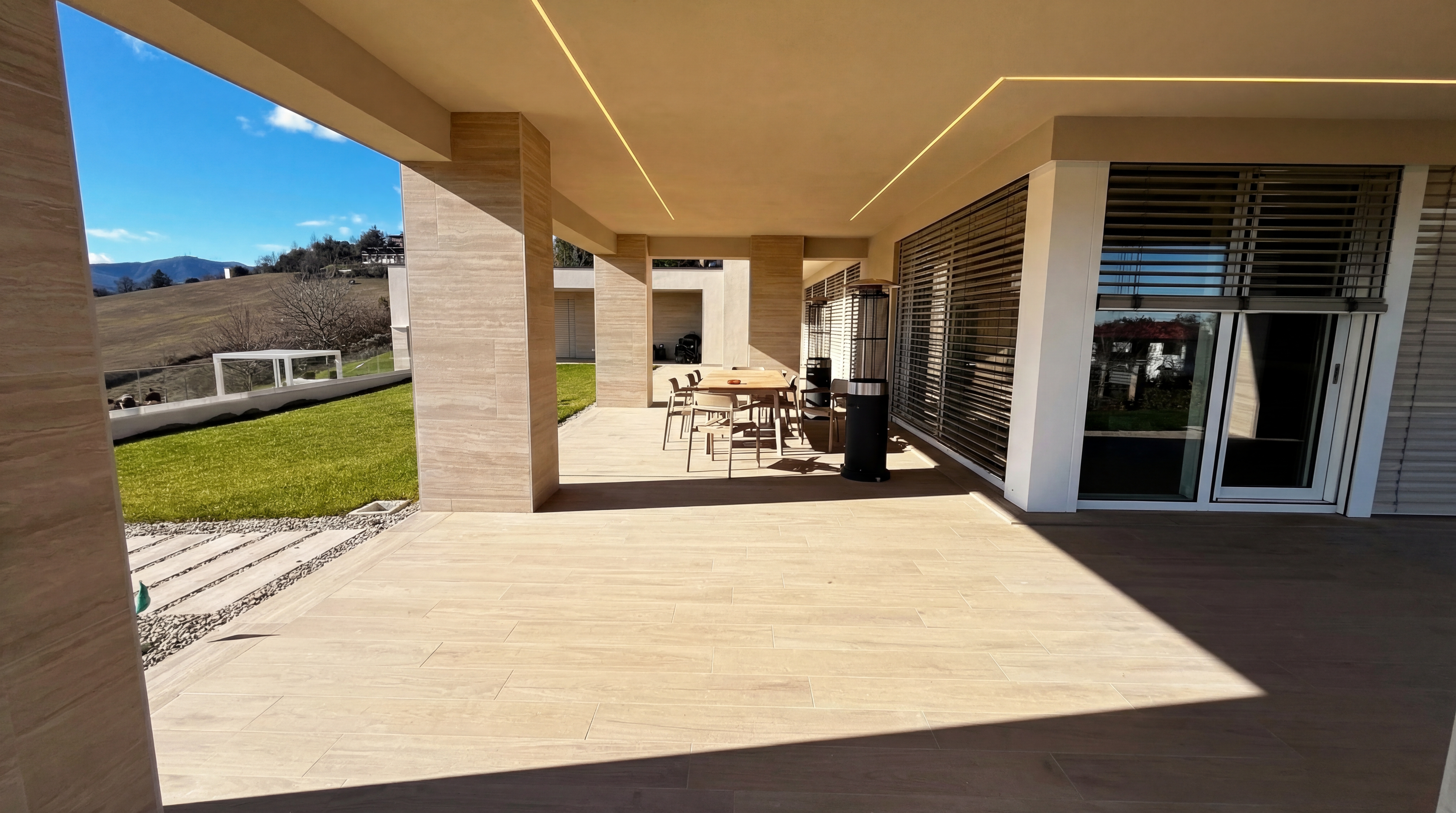 Portico con zona pranzo esterna di Villa L|J, affacciato sulla vallata