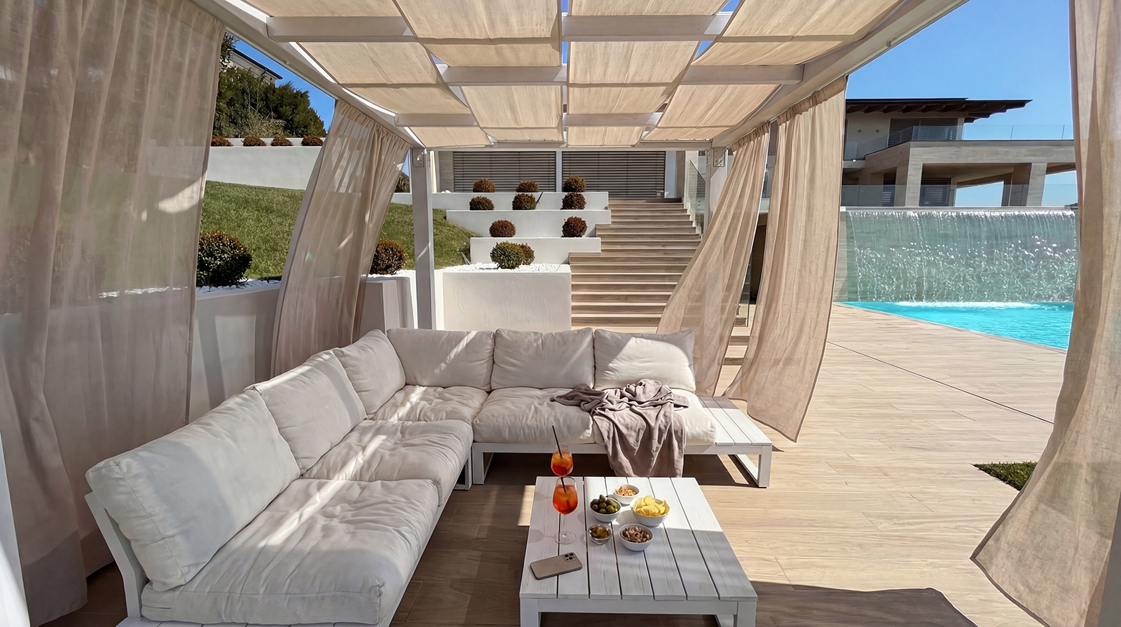 Gazebo con salotto esterno di Villa L|J, affacciato sulla piscina e la scalinata